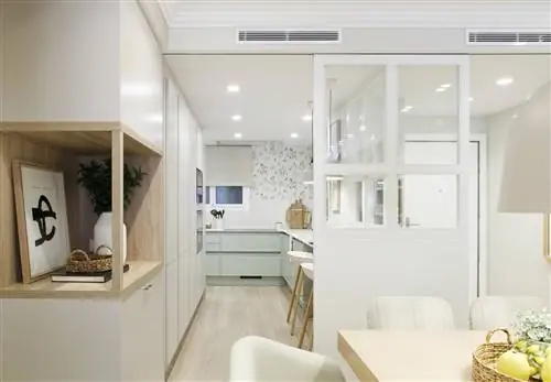 Зеленая кухня с белой раздвижной дверью от Pia Capdevila