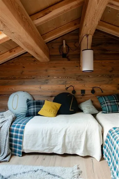 Детская комната на чердаке со стеной, обшитой деревом.