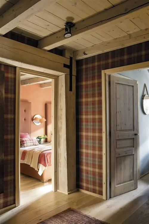 Прихожая украшена обоями и потолком с деревянными балками.