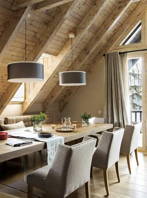 Деревенская столовая с деревянным столом и мягкими стульями.