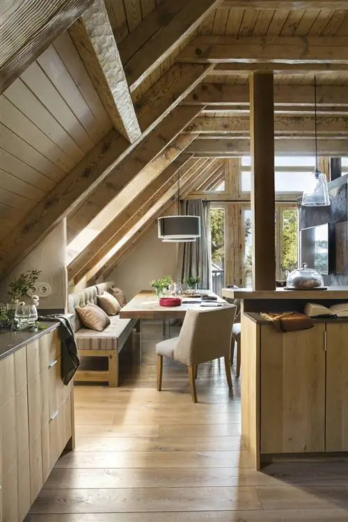 Кухня открыта в столовую со скошенными деревянными потолками.