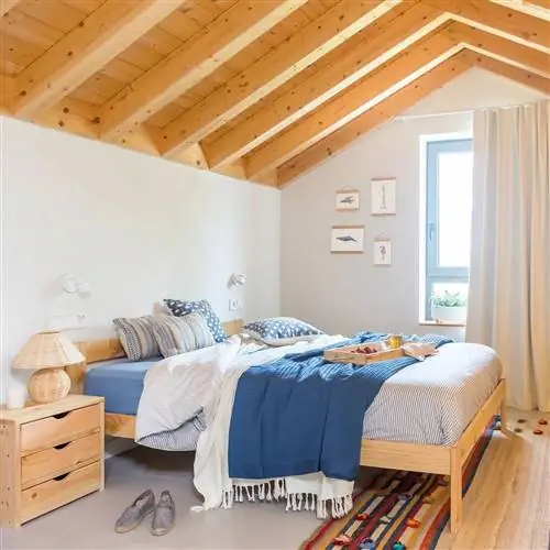 Двуспальная кровать с низким деревянным изголовьем.