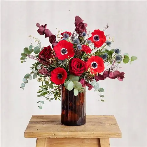 Букет с красными цветами, такими как гвоздики, розы и анемоны и другие детали.