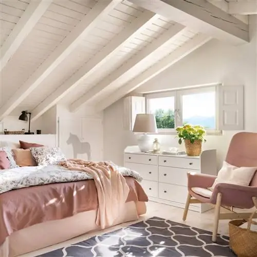 Мансардная спальня окрашена в белый цвет с розовым креслом 00538485