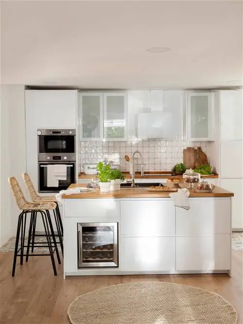 Кухня с островом из белого и дерева со встроенным винным погребом на острове.