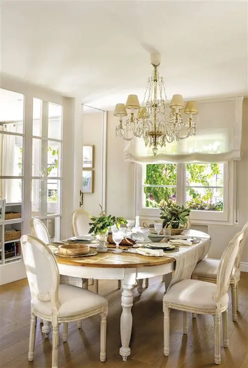 Классическая столовая с деревянным столом, мягкими стульями и люстрой.