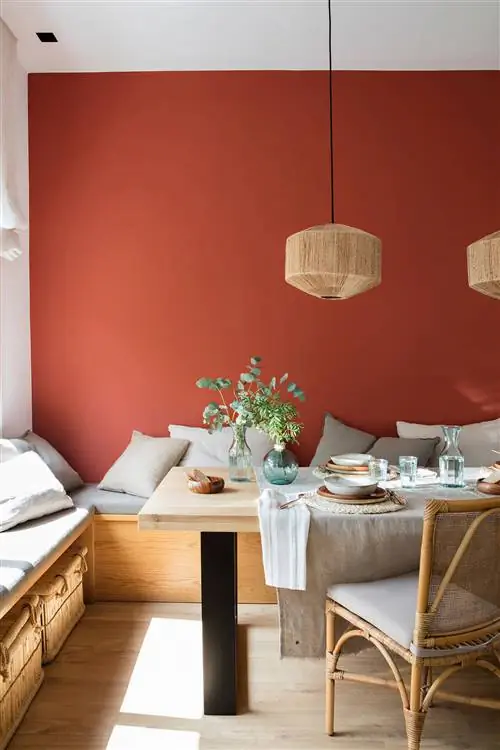 Столовая с темно-бордовой стеной и скамейкой в качестве сидений