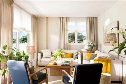 Небольшая гостиная с несколькими диванами и шторами до потолка.