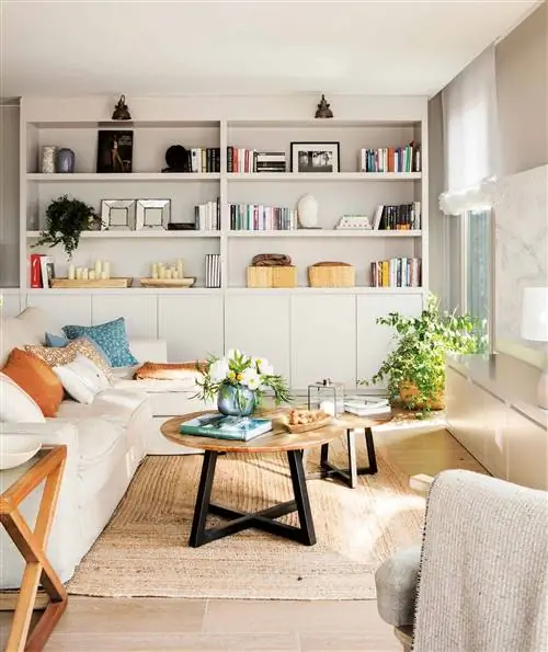 Небольшая гостиная с большим серым книжным шкафом.