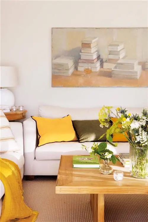 Гостиная с белым диваном и большой картиной на стене.