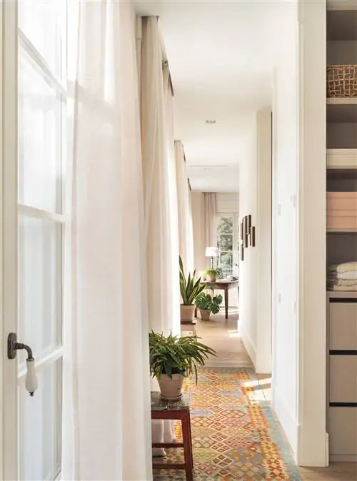 Очаровательная прихожая с ковром из килима и растениями.