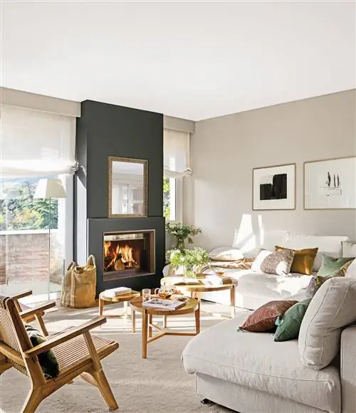 Современная бежевая гостиная и черный камин.