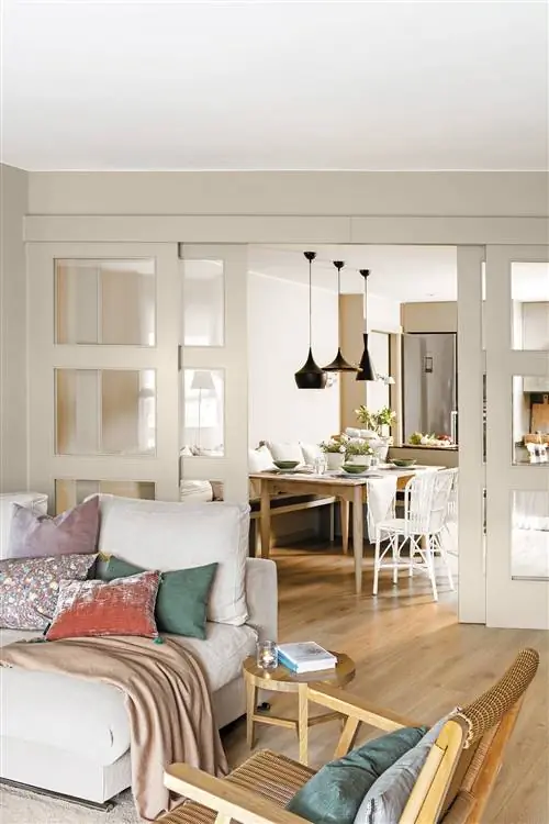 Гостиная соединена с кабинетом и кухней белой раздвижной дверью.