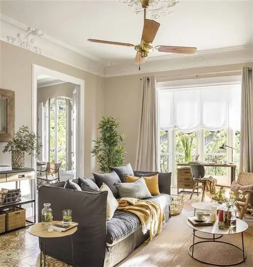 Гостиная с лепниной и серым диваном.