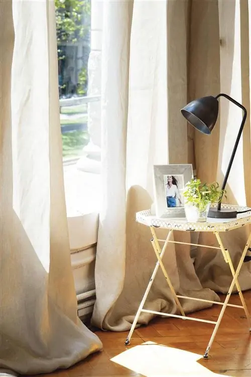 Гостиная с тумбочкой возле окна с занавесками.