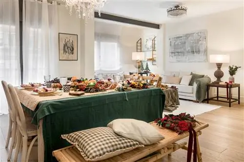 Рождественская столовая с деревянной скамейкой, клетчатыми подушками, зеленой скатертью и рождественскими украшениями.