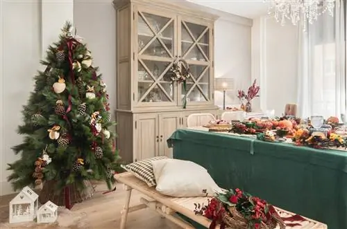 Рождественская столовая с елкой, украшенной сосновыми шишками, апельсиновыми сегментами, серебряной звездой и красным бантом. Дома под деревом, тканью из ягненка и белым орнаментом.