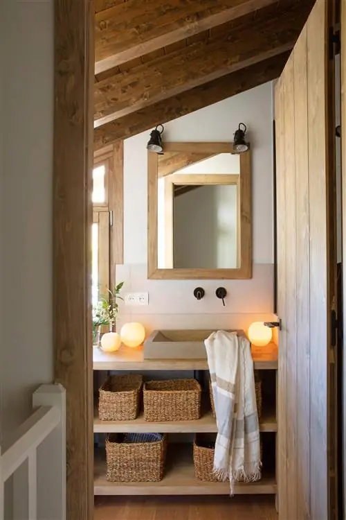Мансардная ванная комната с открытой мебелью и украшена свечами.