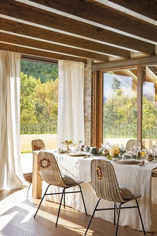 Деревенская столовая с деревянным столом, стульями из волокна и рождественскими украшениями.