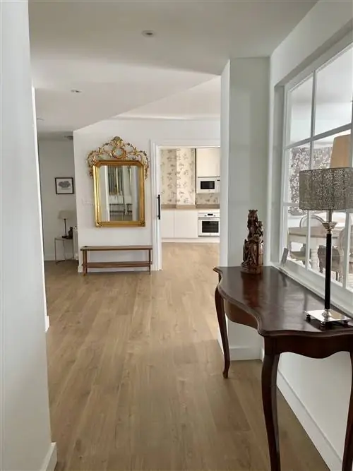 Открытый вход в дневную зону со светлыми деревянными полами и консолью.