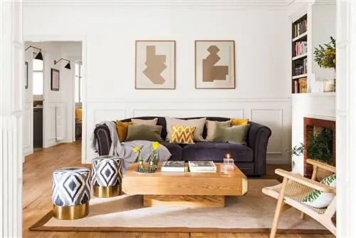 Гостиная с синим диваном, белыми стенами и золотыми деталями.