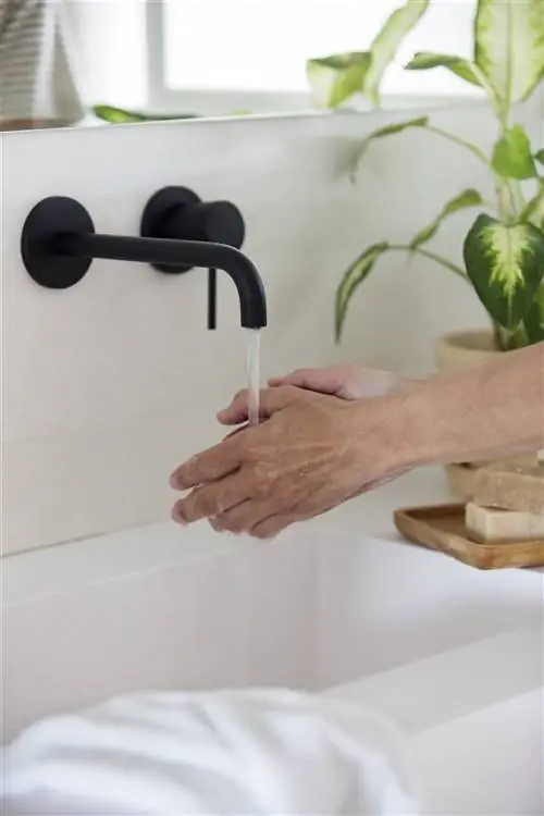 Черные краны, встроенные в стену.