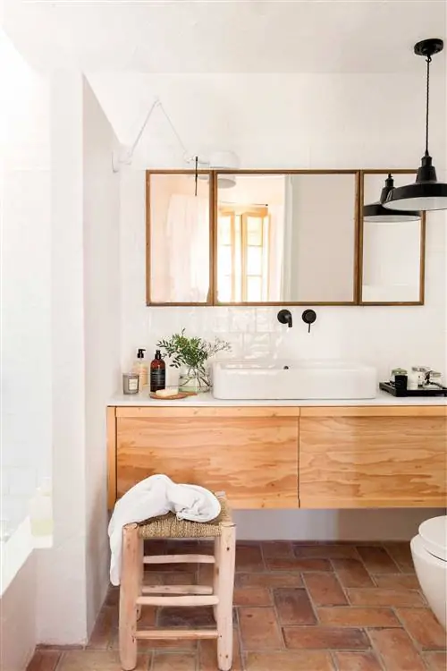 Ванная комната с деревянным шкафом и стеной, отделяющей душевую зону.