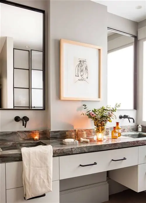 Ванная комната с серыми стенами и шкафом для ванной, мраморной столешницей и покраской.