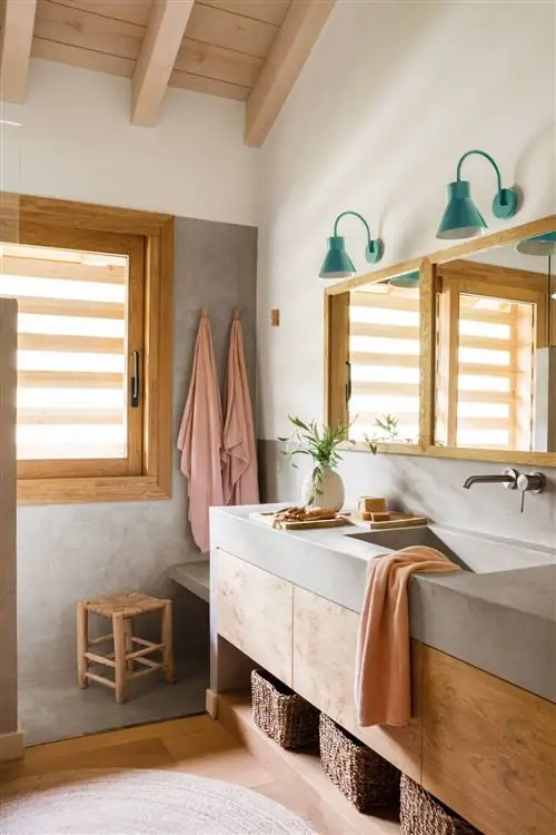 Ванная комната со столешницей и раковиной из микроцемента, деревянной мебелью и ковром из натурального волокна.