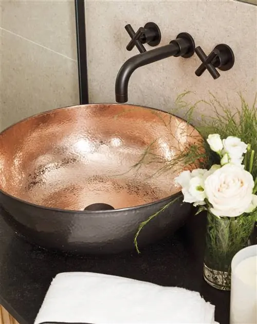 Раковина с медным покрытием и встроенными кранами.