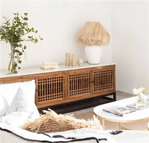 Деталь деревянного шкафа под телевизор в небольшой белой гостиной.