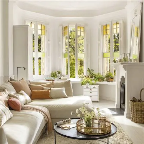 Гостиная с диваном с шезлонгом, круглым журнальным столиком и камином.