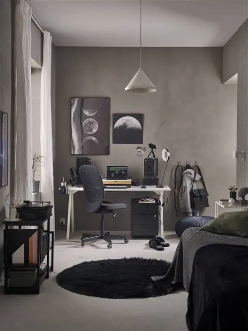 Учебная зона с письменным столом и черным круглым ковриком.