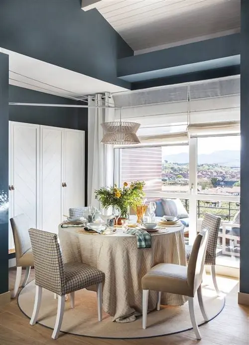 Столовая с круглым столом и мягкими стульями.