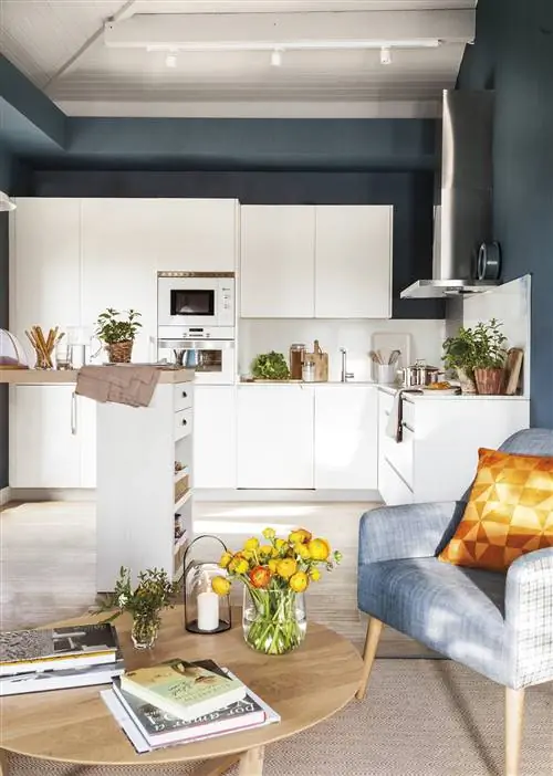 Открытая кухня с белой мебелью и линейным дизайном.