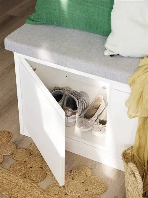 Белая деревянная скамейка с местом для хранения.