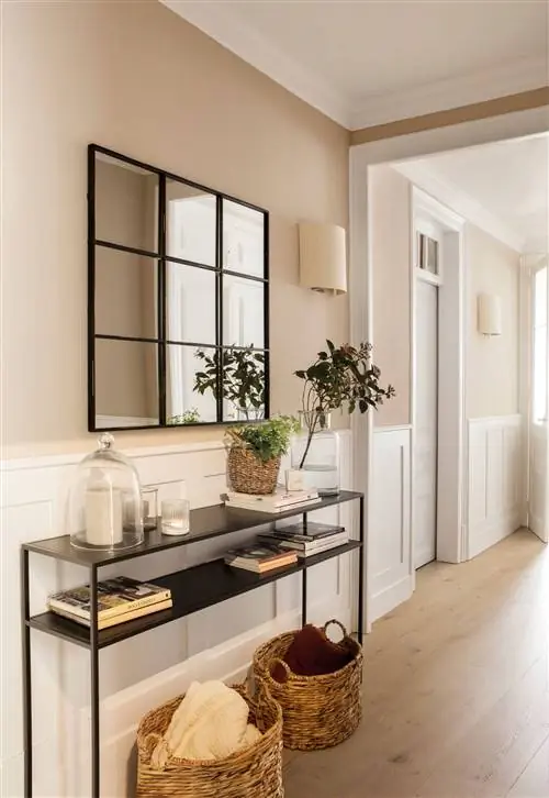 Холл с черной металлической консолью и оконным зеркалом.