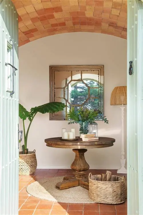 Зал оборудован круглым деревянным столом и состаренным зеркалом.