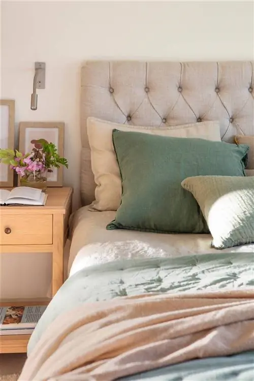 Спальня с изголовьем, обитым серой капитоне.