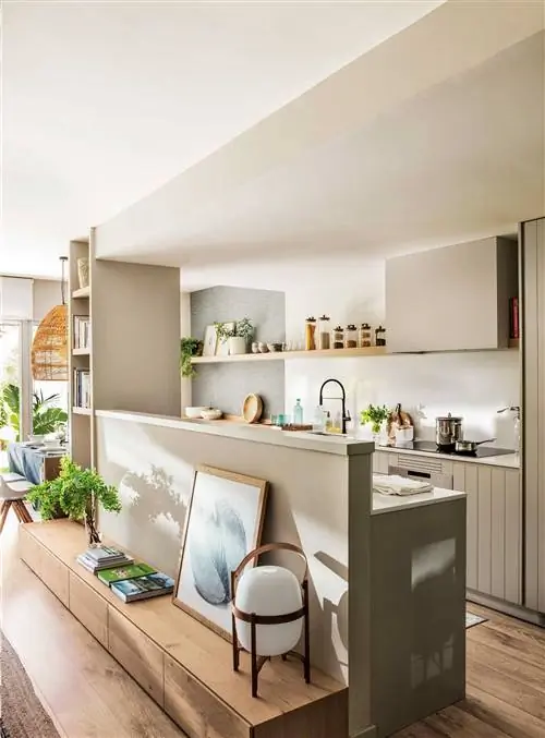 Современная кухня с выходом в гостиную со стеной в качестве разделителя и тумбой под телевизор.