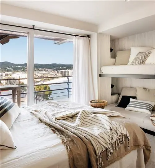 Небольшая спальня с двухъярусной кроватью и двуспальной кроватью.