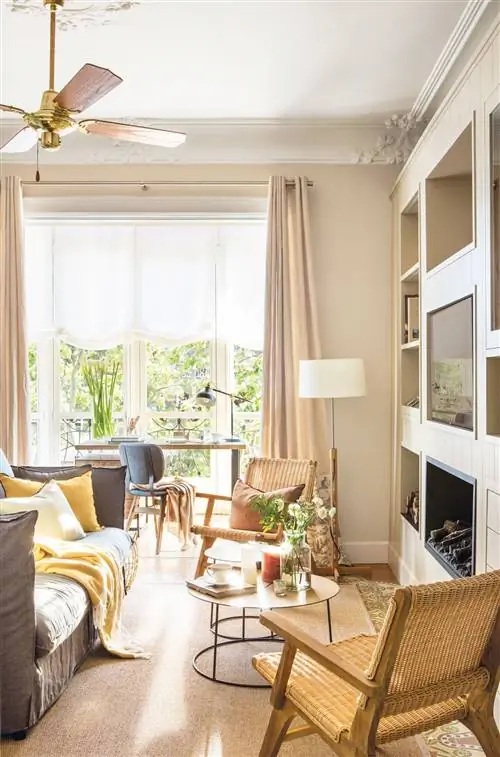 Небольшая гостиная со встроенным книжным шкафом и серым диваном.