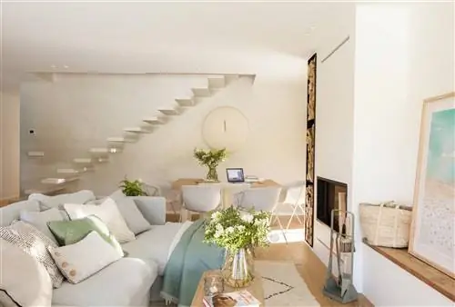 Гостиная с зоной отдыха и обеденной зоной, ограниченной спинкой дивана.