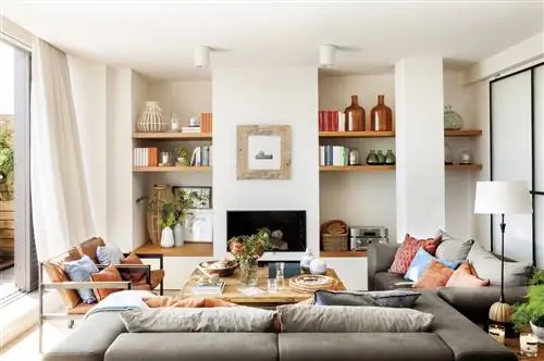 Белая гостиная с камином и деревянными полками.