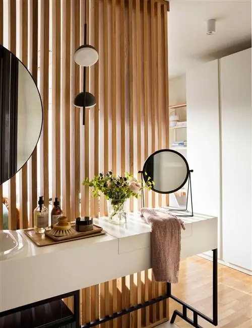 Открытая ванная комната отделена от спальни деревянной решеткой.