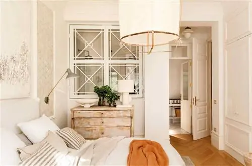 Классическая белая спальня с окном, которое сообщается с ванной комнатой.