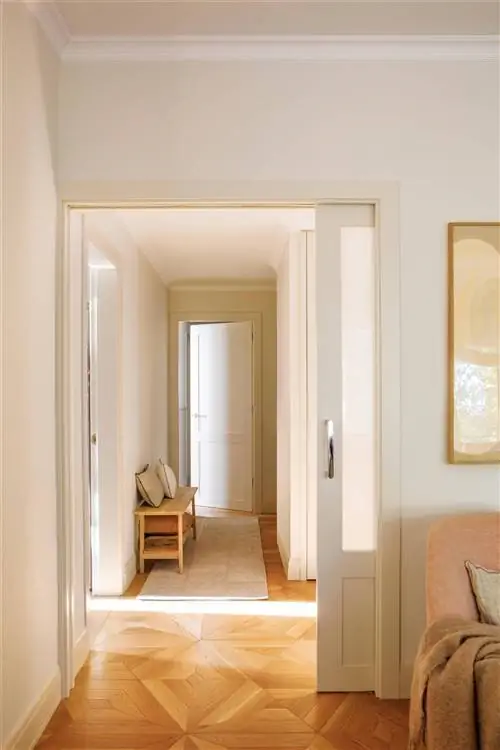 Прихожая со светлым деревянным полом и ковром.