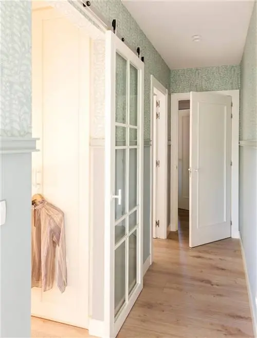 Коридор с раздвижной дверью из белого стекла с открытыми перилами и выходом в гардеробную.