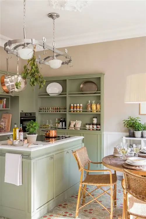 Небольшая кухня с зелеными шкафами и островом.