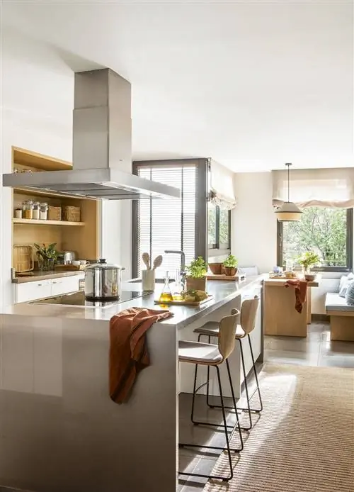 Кухня с белым и серым островом, с деревянной мебелью для завтрака и кабинетом с обоями.